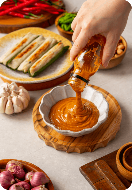 Tikka sauce being poured into a wooden bowl